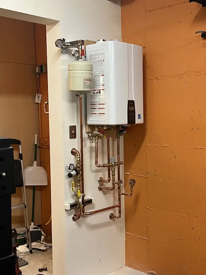 Plumbing technician inspecting water heater connections in Wallburg